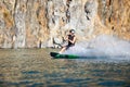 Splash, wakeboarding and water board with man in lake for extreme sports, summer break and travel vacation. Wave Royalty Free Stock Photo