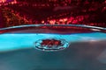 Splash of water on an abstract red backgrounds close up.A frozen drop of water is photographed at high speed.The slow dripping of Royalty Free Stock Photo