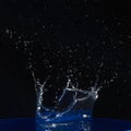 Splash of water crown on blue surface. Royalty Free Stock Photo