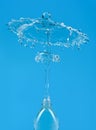 A splash of water with drops escaping from a PET bottle on a blue background. The concept of pure bottled water