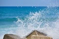 Splash water of sea wave attack to the rock phot with outdoor sunny lighting