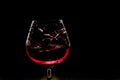 Splash of wine in the glass on dark backround