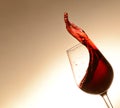 A splash of wine in a tilted wine glass. Ruby color. A smooth transition from light to darker in the background Royalty Free Stock Photo