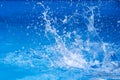 Splashes of clear blue fresh water in pool, air bubbles, water drops, sea wave on blue background with sunny reflections Royalty Free Stock Photo