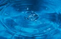 Splashes from a drop of water. Rain drops on a blue background. The texture of the water. Aqua, ripple, turquoise, macro Royalty Free Stock Photo