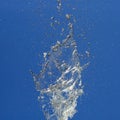 Splashes of flying water from the fountain against the blue sky Royalty Free Stock Photo