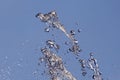 Splashes of flying water from the fountain against the blue sky Royalty Free Stock Photo