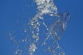 Splashes of flying water from the fountain against the blue sky Royalty Free Stock Photo