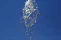 Splashes of flying water from the fountain against the blue sky Royalty Free Stock Photo