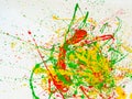 Splashes of red and yellow green paint on a white background