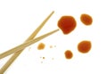 Splashes of soy sauce and chopsticks isolated on white background. Top view Royalty Free Stock Photo