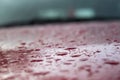 Splashes and water drops on a red car with some parts in focus Royalty Free Stock Photo