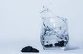 Splashes of water from a glass of water into which shungite stones had fallen