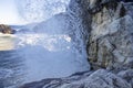 Splashes of water from the sea wave crashed against the stone cliff