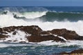 A big wave crashing into the rocks in the rough wild water of the ocean on a stormy during wintertime in South Africa. Royalty Free Stock Photo