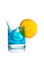 Splashing blue cocktail with ice cube and lemon slice Royalty Free Stock Photo