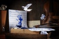 Splashing ink on the rustic workplace of a musician with sheet music, violin, footprints and an origami bird, dark and moody style