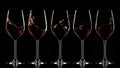 Splashing red wine in glasses on dark background Royalty Free Stock Photo