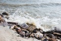 Splashing sea wave hitting rocks on the beach shore. Royalty Free Stock Photo