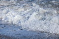 Splashing Sea waves with foam and spray; closeup photo. Sea foam.