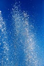 Splashing water from a fountain against the blue sky Royalty Free Stock Photo