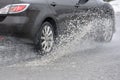 Splashing water from under the car wheels Royalty Free Stock Photo