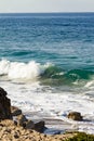 Splashing wave on backwash and sandy beach, with  boulders and sand, Royalty Free Stock Photo