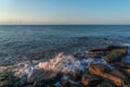 Splashing waves on the coastal cliffs at sunset Royalty Free Stock Photo