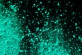 A splatter of green blue colored pigment powder on black background Royalty Free Stock Photo