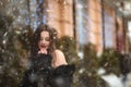 Splendid lady with bare shoulders posing near the Christmas showcase decoration with garlands Royalty Free Stock Photo