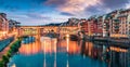 Splendid medieval arched river bridge with Roman origins - Ponte Vecchio over Arno river. Colorful spring sunset view of Florence Royalty Free Stock Photo