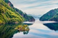 Splendid summer view of small island with red painted Norwegian building on Lovrafjorden flord, North sea. Colorful morning view