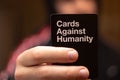 Split,Croatia April 2020 Blurred man in the background holding a black cards against humanity card, popular worldwide party game Royalty Free Stock Photo