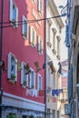 Colorful female boots hanging on rope between houses on old croatian street