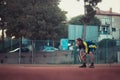 Split Croatia September 2020 Side of a man with longer hair playing tennis outside on an orange clay field. Crouching and resting