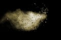 Split debris of brown stone exploding with brown powder against black background