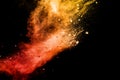 Split debris of stone exploding with orange red powder splash against black background Royalty Free Stock Photo