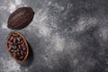Split fermented cocoa pod with shelled cacao beans atop dark grey backdrop, top view Royalty Free Stock Photo