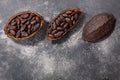 Split fermented cocoa pod with shelled cacao beans atop grey, top view, copy space