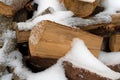 Close view of split hardwood and softwood firewood covered with snow in the winter
