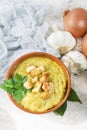 Split pea soup in rustic bowl decorated with fresh green leaves,garlic and slices of lard Royalty Free Stock Photo