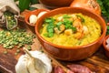 Split pea soup in rustic bowl decorated with fresh green leaves, garlic, onion and slices of lard Royalty Free Stock Photo