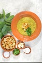 Split pea soup in rustic bowl decorated with fresh green leaves, garlic, onion and slices of lard Royalty Free Stock Photo