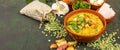 Split pea soup in rustic bowl decorated with fresh green leaves, garlic, onion and slices of lard Royalty Free Stock Photo