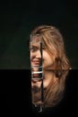 Split. Modern art photography. Beautiful girl& x27;s face through glass of water. Object distortion, optical illusion Royalty Free Stock Photo