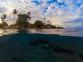 Split photo with tropical island and underwater coral reef. Double landscape with sea and sky. Royalty Free Stock Photo