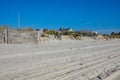 Split rail fence lining a pathway over sand dunes and high grass entering a white sandy beach Royalty Free Stock Photo