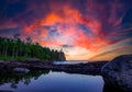 Split Rock lighthouse on the cliff under the orange and blue sunset sky reflecting in the water Royalty Free Stock Photo