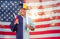 Split Screen Male Hispanic Graduate In Cap and Gown to Engineer in Hard Hat in Front Of American Flag Royalty Free Stock Photo