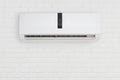 Split system air conditioning unit on decorative white brick wall Royalty Free Stock Photo